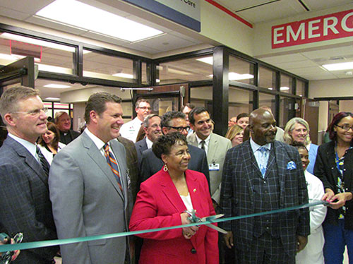 Joined by staff members and administrators as they prepare to cut ribbon during "ECMC Center for Orthopaedic Care" grand opening event held Thursday, April 7, 2016 (shown front row left to right) are: ECMC Orthopaedics chief of service Dr. Philip Stegemann; ECMC Corp. president & CEO Thomas Quatroche, PhD; ECMC Corp. board chair Sharon Hanson (with scissors); ECMC Corp. board vice chair Michael Seaman (second row); and ECMC Corp. board treasurer Bishop Michael Badger.