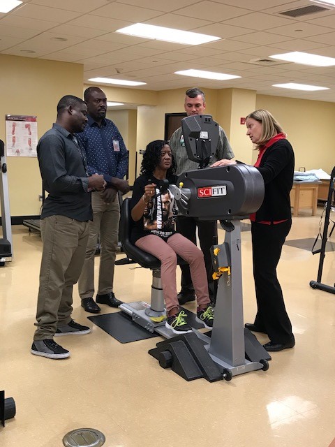 Haitian rehabilitation therapists Wilfred Macena and Cedieu Fortilus observe auto accident patient exercising.